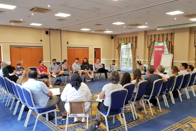 Group_sitting_down_together_in_large_room